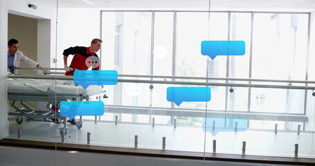 Medical team in coat and uniform pushing stretcher with patient in hospital hall with speech icons
