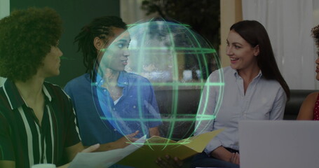 Reviewing data on laptop, four professionals collaborating in office lounge, with holographic globe