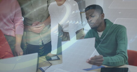 Analyzing printed documents and digital displays by professionals at conference table, copy space