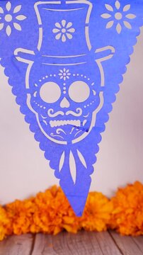 Blue papel picado decoration with a skull and Catrin decorations. Decoration for Day of the Dead