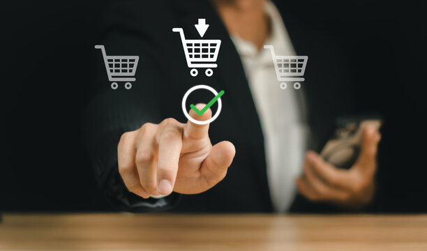 E-commerce service store. client purchase shopping online retail store. A man is holding a shopping cart in his hand, with a green check mark on it.