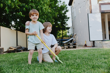 Two happy boys playing joyfully in a sunny garden, enjoying their childhood with colorful water...