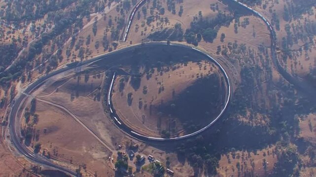 A long freight train crosses over itself in this aerial view of the famous Tehachapi Loop in Kern County, California.