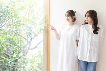 壁にもたれる二人の女性