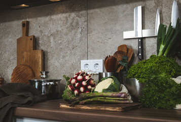 Fresh vegetables and herbs on a kitchen countertop ready for preparation in a cozy cooking space