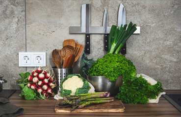 Fresh vegetables and herbs on a kitchen counter, ready for healthy meal preparation from a farmer's...