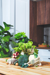 Fresh vegetables and herbs on a table in a beautiful kitchen, ready for cooking healthy meals using market produce