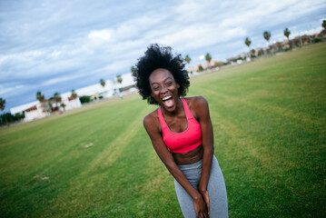 woman laughing while taking a break from her outdoor workout