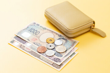 黄色背景にお金と財布