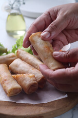 hand holding Fried spring rolls filled with meaty bolognese sauce and mozarella cheese
