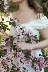 Faceless Spring Portrait of a Young Woman with Apple Blossoms and White Dress