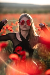 Poppy Flowers Woman Nature: Girl playfully covers eyes with poppies in blooming field during sunny summer day.