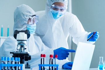 Scientist man look into Microscope research in science laboratory. Asian scientist looking...