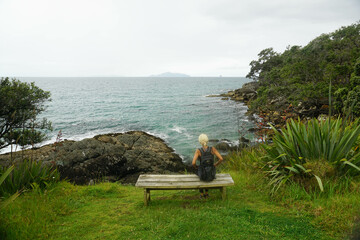 a woman walking around Waipu pancake rocks in Waipu, New Zealand.