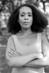 Confident woman with folded arms in monochrome analog style