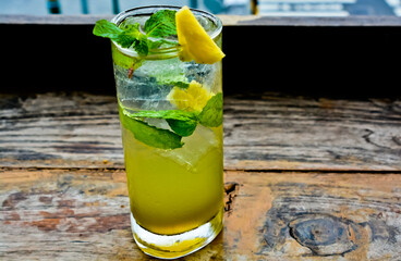 view of a glass of lime ice with mint leaves and lemon topping