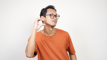 A man in an orange shirt is smiling and pointing to the camera
