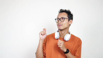 A man in an orange shirt is smiling and holding up his thumbs up