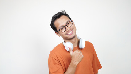 A man in an orange shirt is smiling and holding up his thumbs up