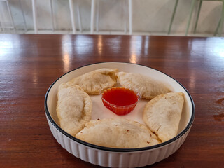 Close-up of crispy fried stuffed cireng served on a plate. Filled with seasoned chicken, this...