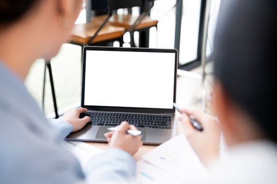 Mockup image of a two woman using laptop with blank screen on wooden table - Powered by Adobe
