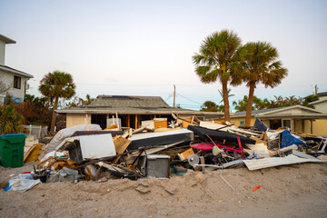 Hurricane damage in Florida. Piles of rubbish on street side from destroyed houses. Consequences of...