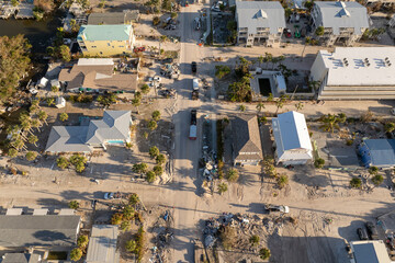 Hurricane Milton aftermath cleanup. Workers picking up piles of debris and sand on street side on...