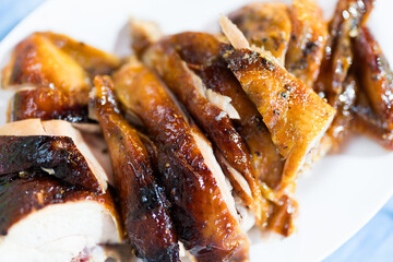 Grilled chicken cut into slices served on a plate. Thai food