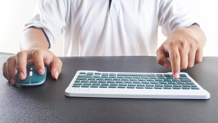 Portrait of a man typing on a green modern wireless computer keyboard isolated on white background