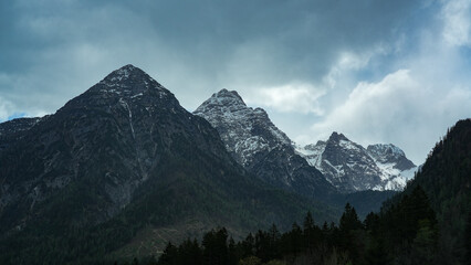 mountain landscape with clouds and snow on top