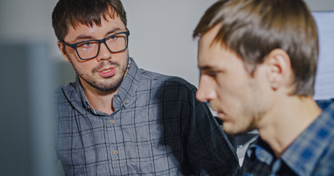 Team adult male engineer collaborate on robotic hand project using AI code solutions machine learning at tech workspace. Artificial intelligence interface, collaboration support prototype development.