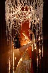 Young Caucasian circus performer or burlesque dancer in golden vintage corset, front view, posing...