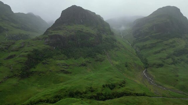Aerial view of Glencoe mountain range in the Scottish Highlands on a moody rainy day, Scotland, United Kingdom. Scottish rugged landscape.