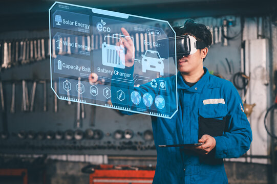 A man in a blue jumpsuit uses virtual reality to interact with a holographic interface displaying renewable energy and eco-friendly technology information.