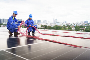 Electrical engineers are inspecting and installing a solar panels on the building rooftop.