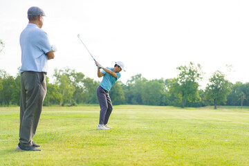Asian man and elderly father are enjoy playing golf together with a good time.