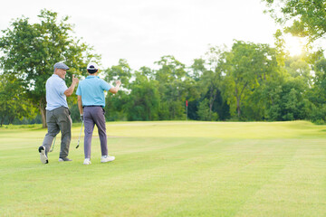 Asian man and elderly father are enjoy playing golf together with a good time.