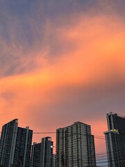 Sunset Skyline over Bangkok City with Colorful Orange-Pink Clouds and Tall Buildings.
