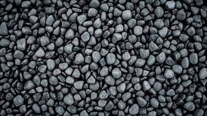 Dark gray irregular stones spilled from container simple texture background
