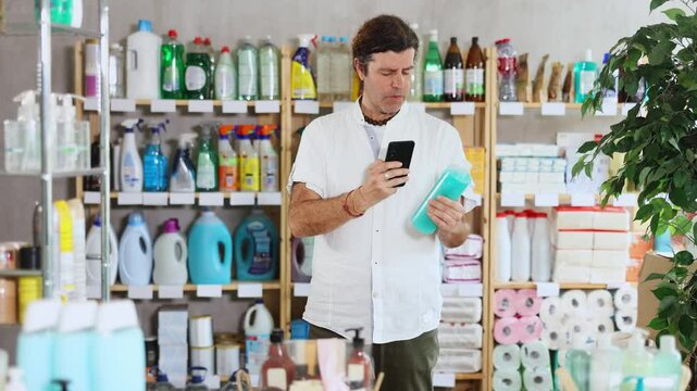 Man customer scans qr code on shampoo or shower gel label. Customer follows link and reads information about product, data on recycling of packaging