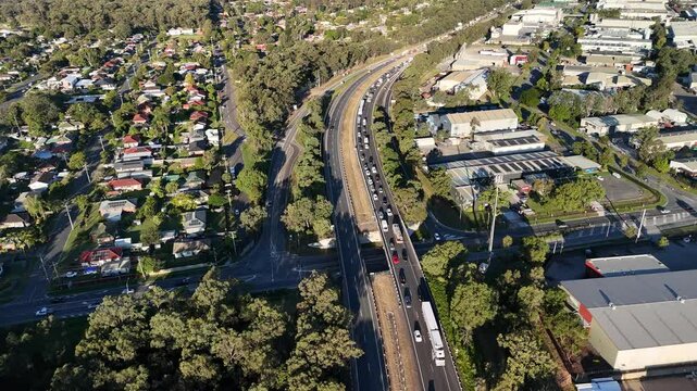 Logan Motorway, Carole Park, South Brisbane, Queensland, Australia: 4k Aerial Footage of Multi Lane Freeway, Vehicles, Trucks, Overpass, and Adjacent Greenbelt and Creek Infrastructure