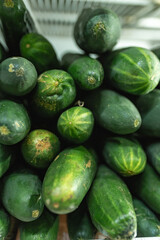Fresh cucumbers stacked vertically at local market