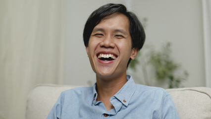 Happy Asian man smiling and laughing with joy.