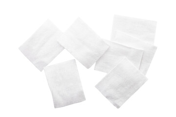 Seven white cotton pads scattered on white background