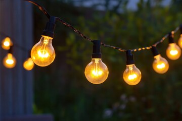 Old-Fashioned Lightbulb Illuminated at Night with Bright Yellow String of Lights
