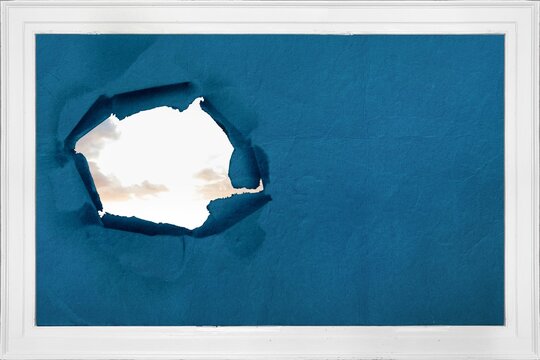 Fototapeta Rip on wall showing bright sky
