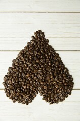 Heart-shaped coffee beans are forming on white painted wooden plank background in flat design