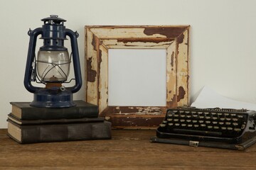 Photo frame, lantern and typewriter on table