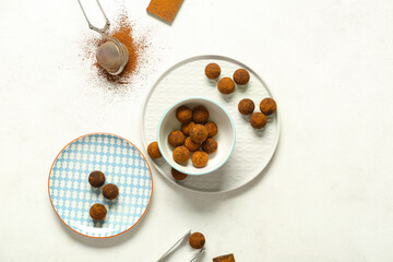 Plates with tasty chocolate truffles on white background