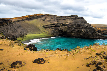 A coastal view of Green Sand Beach on the Big Island of Hawaii, known for its rare olive-colored...